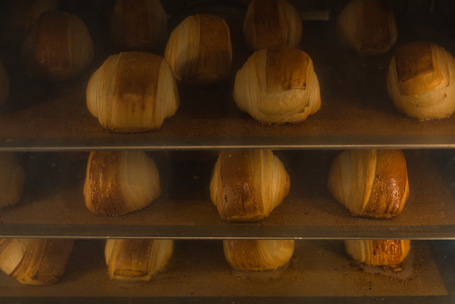 Golden croissants baking in an artisan oven, showcasing delicious pastry textures.